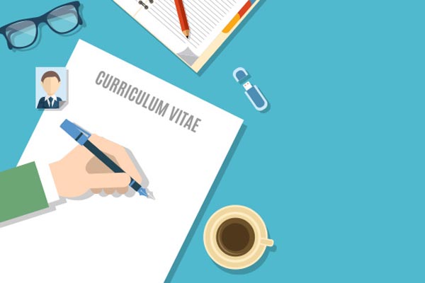 There is a white Paper on the table and someone is writing curriculum vitae for Myra's Academy with having a coffee cup, a passport size photo and spectacles.